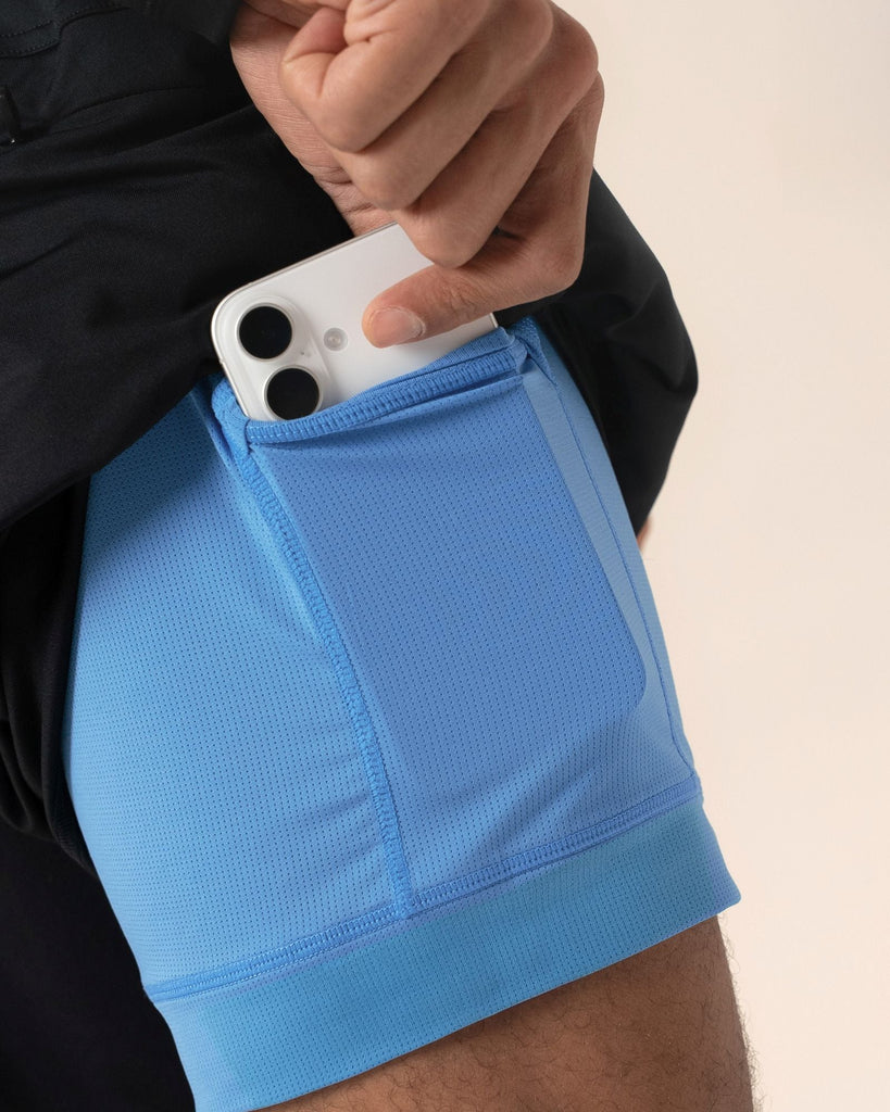 Close-up of secure hidden phone pocket on black 2-in-1 shorts