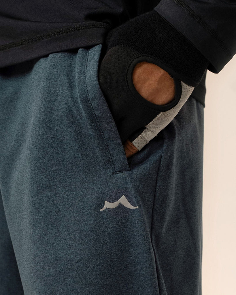 Detail of  back pocket and elastic waistband on navy blue joggers